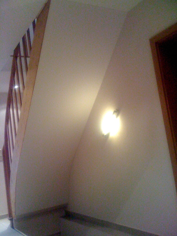 Auf diesem Bild ist eine Spanndecke unter einem Treppenaufgang zu sehen, nach der Installation.